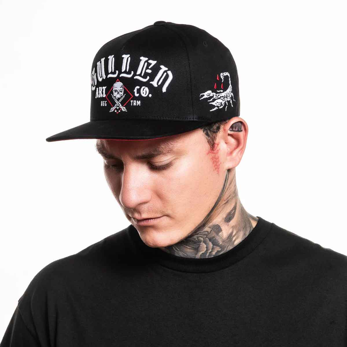 Person wearing a black cap with branding on a white background