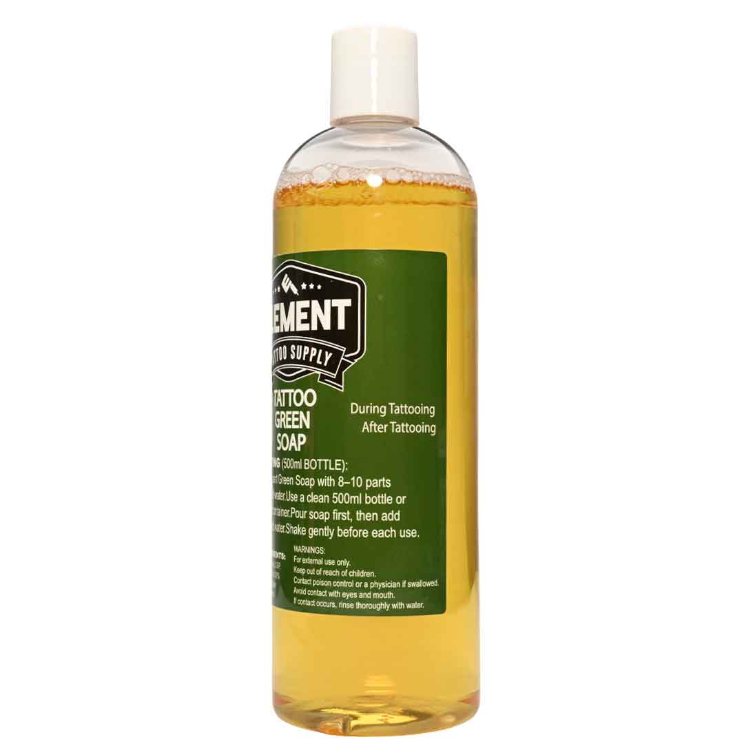 A clear plastic bottle of Tattoo Green Soap by Tattoo Element Supply, filled with yellow-amber liquid and featuring a dark green label with white text, on a white background.
