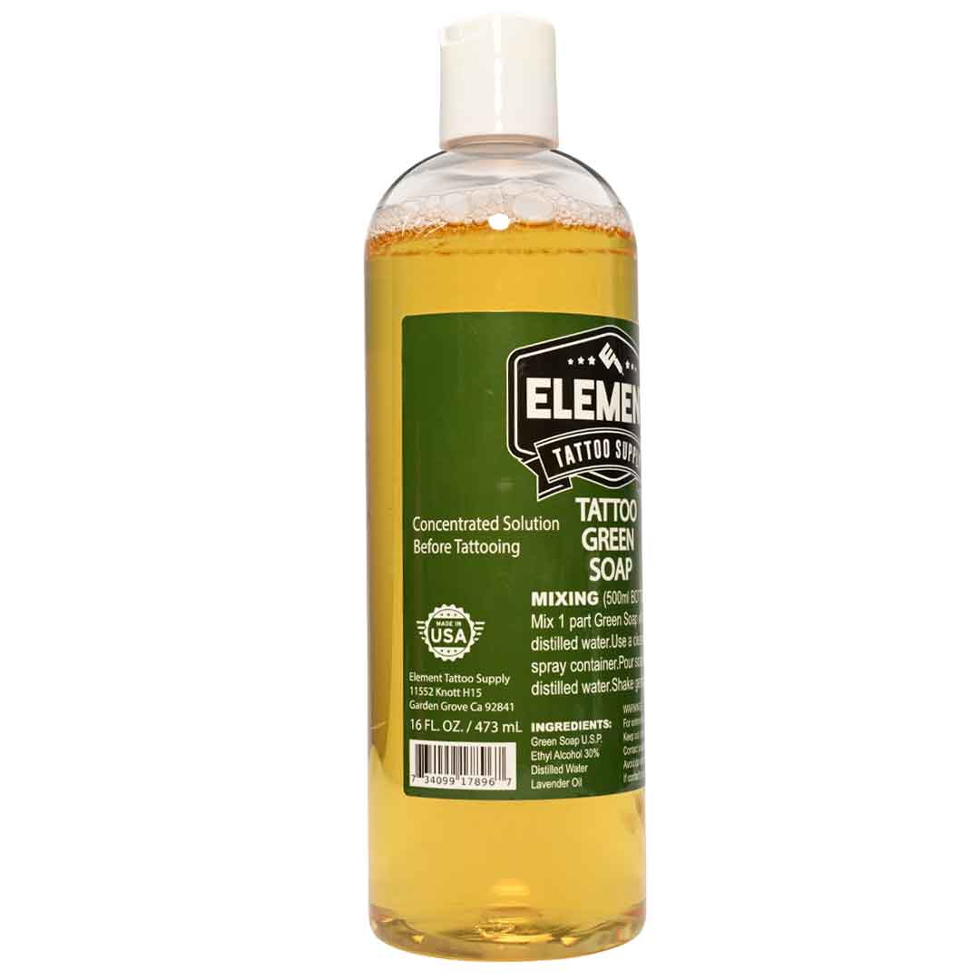 A bottle of Element Tattoo Soap concentrated solution before tattooing, featuring a green label and white cap, filled with yellow liquid, on a white background.