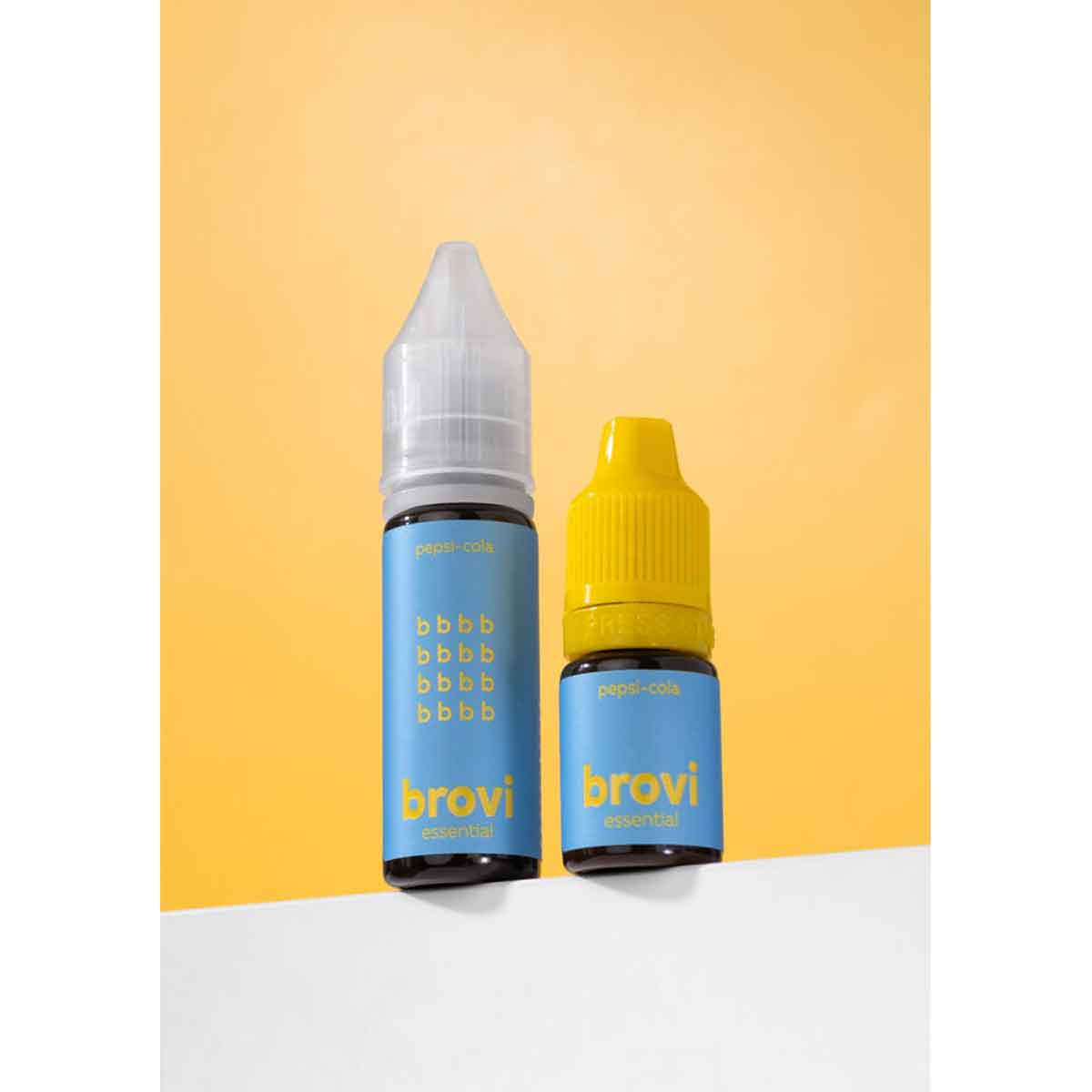 Two Brovi essential oil bottles standing on a white surface against a warm yellow background. One bottle has a light blue label and a white cap, and the other has a light blue label and a yellow cap.