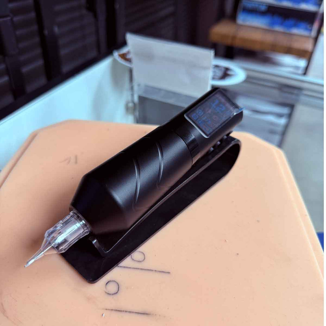 Tattoo machine held over skin with a blurred background